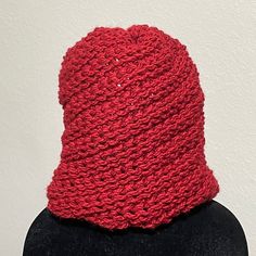 a red knitted hat sitting on top of a mannequin's head