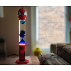 a spiderman toothbrush holder on a table in front of a couch and window