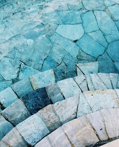 an aerial view of stone steps leading up to the water's edge in blue hues