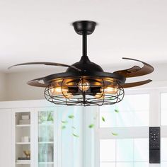 a ceiling fan that is hanging from the ceiling in a room with white walls and windows