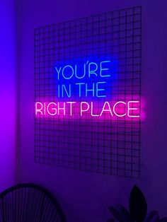 a neon sign that says you're in the right place on a purple wall