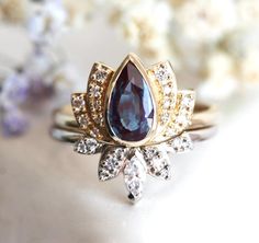 a close up of a ring on a table with flowers in the background