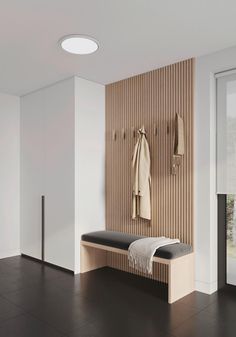 a coat rack with two coats hanging on it next to a bench in a room