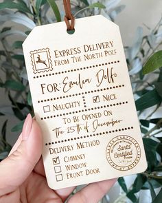 a hand holding a wooden luggage tag with the words express delivery from the north pole