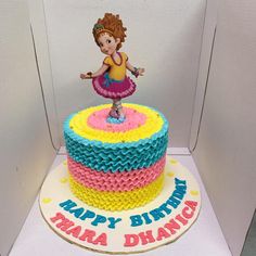 a birthday cake with a girl on top in the shape of a rainbow ballerina