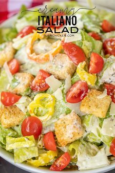 a salad with croutons, tomatoes and lettuce in it on a plate