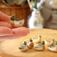 a person is holding some tiny figurines in their hand and they are sitting on a table