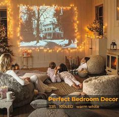 a family sitting in front of a christmas tree watching a movie on the tv screen