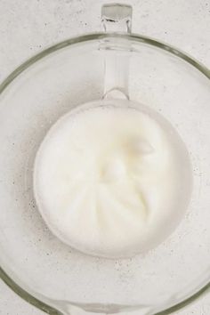 a bowl filled with white liquid on top of a table