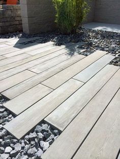 a wooden deck surrounded by rocks and plants