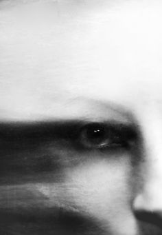 a black and white photo of a person's face with blurry lines in the background