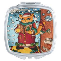 a compact mirror with an image of a cat holding a book and wearing a santa hat