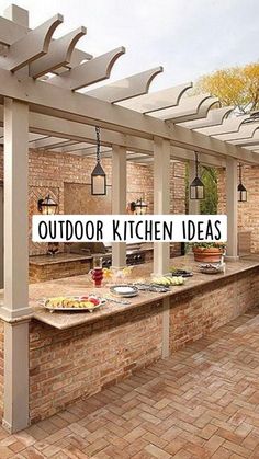 an outdoor kitchen is shown with brick flooring and pergolated roof over it