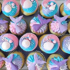 cupcakes decorated in pastel colors with seashells and mermaid tail decorations