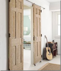 an open door leading to a bedroom with a guitar on the floor next to it