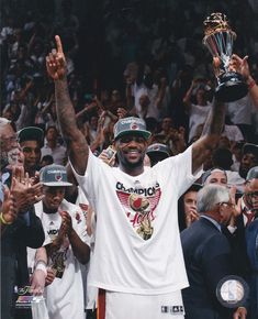 the professional basketball player is holding up his trophy