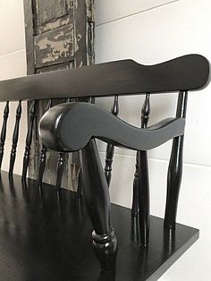 a black chair sitting on top of a wooden shelf