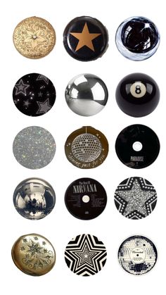 many different types of buttons on a white surface with black and gold stars in the middle