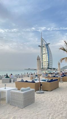 the beach is crowded with people and umbrellas in front of the burj