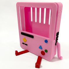 a pink toy computer with buttons and keys on it's face, sitting on its legs