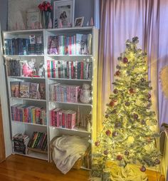 a christmas tree in front of a book shelf