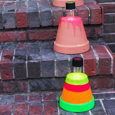 three different colored cones sitting next to each other on brick steps, with one being filled with liquid