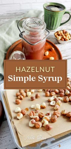 hazel nut simples syrup in a glass jar on top of a tray with nuts