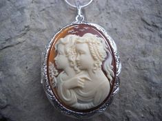 Beautiful cameo locket!!!  The cameo is beautifully detailed!!!  Wonderful gift for sisters, mothers, daughters, and friends!!!! The locket is victorian style with beautiful scroll on the front and back about 2" long.  It can hold two photos, keepsakes, or even your daily medication or vitamins!!! Pass down from generation to generation!!! The chain is 22"  1.2mm .925 plated snake chain with a lobster claw clasp!!! Perfect  for Brides or Bridal parties.  Makes a unique memorable gift for any occ Elegant Cameo Locket Necklace For Wedding, Cameo Medallion Locket Necklace For Weddings, Medallion Locket Necklace For Keepsakes, Carved Oval Necklaces For Weddings, Carved Medallion Jewelry For Wedding, Oval Carved Necklaces For Wedding, Carved Medallion Jewelry For Weddings, Cameo Locket, Friends High