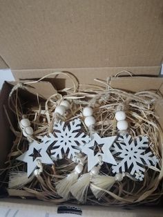 two snowflakes in a box with some tassels on the side