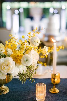 a vase with flowers and candles on a table