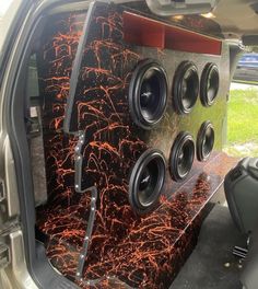 the inside of a vehicle with speakers in it's back seat and an open trunk door