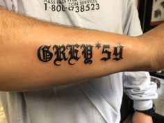 a man with a tattoo on his arm that says grizzly 54 in black ink