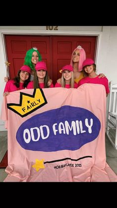 four girls in pink dresses are holding a sign that says odd family on it and there is a yellow crown above the sign