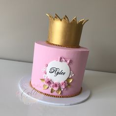 a pink cake with gold crown on top