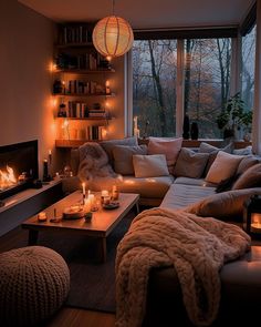 a living room filled with lots of furniture next to a window covered in candles and blankets