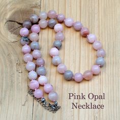 This stunning Pink Opal Necklace features 10mm beads with delicate pink and gray shades, creating a sophisticated and elegant look. Hand-knotted with pink thread, each bead is securely placed to ensure durability and comfort. The necklace is finished with a steel clasp and includes a 2-inch extender, allowing you to adjust the length from 19 inches up to 21 inches. Perfect for any occasion, this gemstone necklace makes a beautiful statement piece and a thoughtful gift for women who appreciate un Pink Opal Round Beads Necklace, Pink 8mm Beaded Necklace, Pink Necklaces With 8mm Beads, Pink Rose Quartz Necklace With 8mm Beads, Gray Shades, Pink Thread, Knotted Necklace, Gemstone Beads Jewelry, Pink And Gray