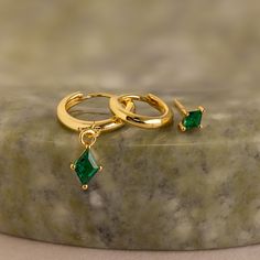 Celebre una ocasión especial con nuestro juego de aretes con dijes de esmeralda, que incluye tres aretes únicos con piedras preciosas de esmeralda que complementan cualquier atuendo. Las esmeraldas verdes vibrantes simbolizan la renovación y el crecimiento, ¡perfectas para agregar un toque de color y mística!

 Este anuncio se puede comprar como un juego de 3 aretes individuales o como un juego completo de 3 pares de aretes (Ahorre 10%). Puede elegir la opción que desee en el menú desplegable. Green Gold Plated Earrings Fine Jewelry, Green Gold-plated Earrings For Anniversary, Green Gold Plated Earrings For Anniversary, Yellow Gold Emerald Hoop Earrings For May Birthstone, Emerald Yellow Gold Hoop Earrings For May Birthstone, Anniversary Green Gold-plated Earrings, Green Dangle Hoop Earrings For Anniversary, Elegant Gold Plated Green Hoop Earrings, Elegant Green Gold-plated Hoop Earrings