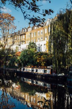 there is a boat that is on the water in front of some buildings and trees