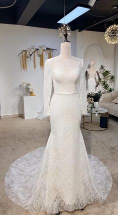 a white wedding dress on display in a room