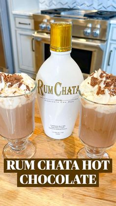 rum chata hot chocolate with whipped cream in two glasses and a bottle on the counter