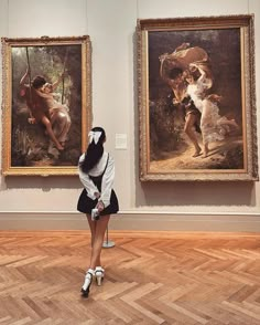 a woman standing in front of two paintings