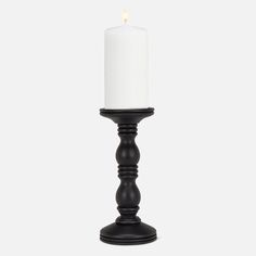 a black candle holder with a white candle