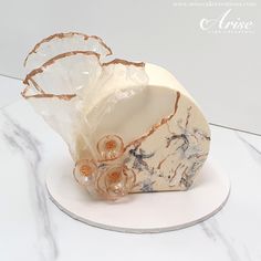 a white and gold object sitting on top of a marble slab with flowers in it