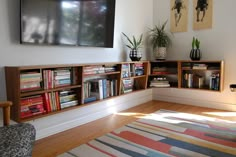 a living room filled with furniture and a flat screen tv mounted to the side of a wall