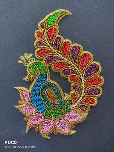 an embroidered patch with a colorful peacock on it