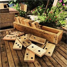 wooden dominos laid out on a deck in front of some flowers and wicker baskets