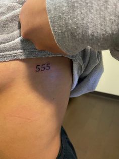 a woman's lower back with the number 555 on her left side,