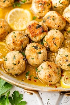 a pan filled with meatballs covered in sauce and garnished with parsley