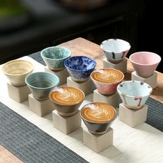 there are many cups on the table with different shapes and sizes in them, including latte or cappuccino