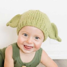 a smiling baby wearing a knitted hat